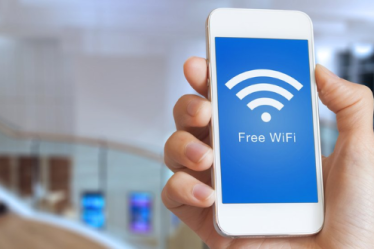 無料の wifi キーを使用してインターネットにアクセスする男性