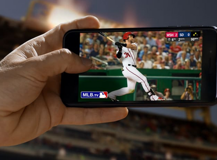 Egy férfi, aki alkalmazásokat használ, hogy baseballt nézzen a mobiltelefonjáról