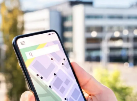 Un joven sostiene su android y muestra diferentes apps para rastrear a otras personas